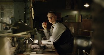 Movie still from “The Death of Stalin” (2017), directed by Armando Iannucci – A man sitting in front of a desk holding an apple; Medium shot, Low angle