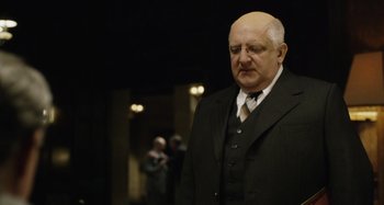 Movie still from “The Death of Stalin” (2017), directed by Armando Iannucci – An old man in a suit and tie; Close Up shot, Over the shoulder angle