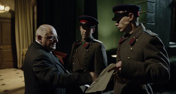 Movie still from “The Death of Stalin” (2017), directed by Armando Iannucci – Three men in military uniforms stand in front of an older man; Medium shot, Over the shoulder angle