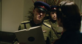 Movie still from “The Death of Stalin” (2017), directed by Armando Iannucci – Two men in military uniforms are looking at a laptop computer; Medium shot, Over the shoulder angle