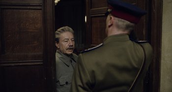 Movie still from “The Death of Stalin” (2017), directed by Armando Iannucci – A man in a uniform talking to another man in a uniform; Medium shot, Over the shoulder angle