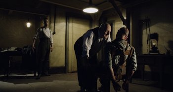 Movie still from “The Death of Stalin” (2017), directed by Armando Iannucci – A group of men standing around in a room; Wide shot, Over the shoulder angle