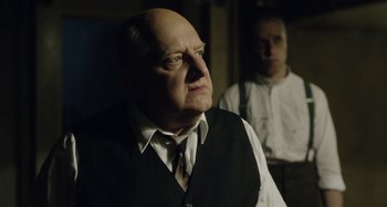 Movie still from “The Death of Stalin” (2017), directed by Armando Iannucci – An older man wearing a vest and a tie; Close Up shot, Over the shoulder angle