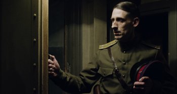 Movie still from “The Death of Stalin” (2017), directed by Armando Iannucci – A man dressed in military clothing holding a gun; Medium shot, Low angle