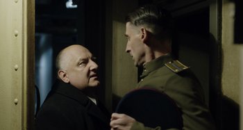 Movie still from “The Death of Stalin” (2017), directed by Armando Iannucci – Two men are talking to each other in the dark; Medium shot, Over the shoulder angle