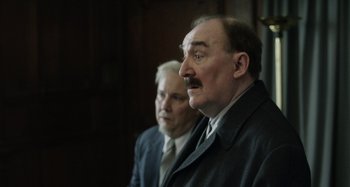 Movie still from “The Death of Stalin” (2017), directed by Armando Iannucci – A man with a mustache standing next to another man; Close Up shot, Over the shoulder angle