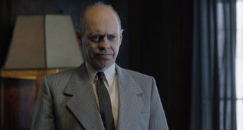Movie still from “The Death of Stalin” (2017), directed by Armando Iannucci – An older man wearing a suit and tie; Close Up shot, Over the shoulder angle