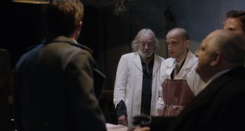 Movie still from “The Death of Stalin” (2017), directed by Armando Iannucci – Two men in white lab coats looking at each other in front of a mirror; Medium shot, Over the shoulder angle