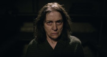 Movie still from “The Death of Stalin” (2017), directed by Armando Iannucci – A woman with long dark hair is looking at the camera; Close Up shot, High angle