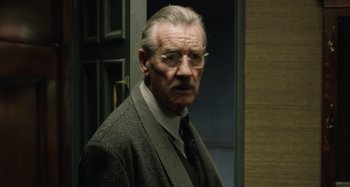 Movie still from “The Death of Stalin” (2017), directed by Armando Iannucci – An older man wearing a suit and tie; Close Up shot, Over the shoulder angle