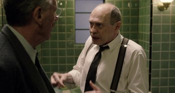 Movie still from “The Death of Stalin” (2017), directed by Armando Iannucci – A man in a white dress shirt and black neck tie talking to another man in a white dress shirt and black neck tie in a bathroom; Medium shot, Over the shoulder angle