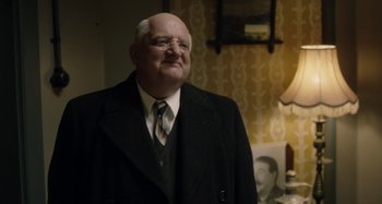 Movie still from “The Death of Stalin” (2017), directed by Armando Iannucci – An older man wearing a suit and tie; Medium shot, Over the shoulder angle