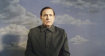 Movie still from “The Death of Stalin” (2017), directed by Armando Iannucci – A painting of a man in a black suit with clouds in the background; Medium shot, Low angle