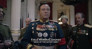 Movie still from “The Death of Stalin” (2017), directed by Armando Iannucci – A man in a military uniform standing in front of a group of people; Medium shot, Over the shoulder angle