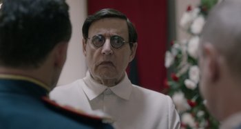 Movie still from “The Death of Stalin” (2017), directed by Armando Iannucci – An older man wearing glasses and a white shirt; Close Up shot, Over the shoulder angle