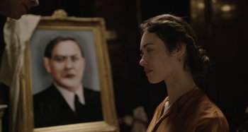 Movie still from “The Death of Stalin” (2017), directed by Armando Iannucci – A woman standing in front of a picture of a man; Close Up shot, Over the shoulder angle