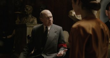 Movie still from “The Death of Stalin” (2017), directed by Armando Iannucci – An older man wearing a suit and tie talking to a young woman; Medium shot, Over the shoulder angle