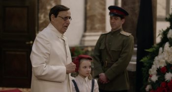 Movie still from “The Death of Stalin” (2017), directed by Armando Iannucci – An older man and a young girl in uniform; Medium shot, Over the shoulder angle