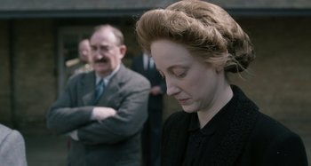 Movie still from “The Death of Stalin” (2017), directed by Armando Iannucci – An old man and a young woman standing next to each other in front of an older man; Close Up shot, Over the shoulder angle