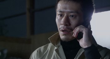 Movie still from “Cold Fish” (2010), directed by Sion Sono – A person talking on a cell phone; Close Up shot, Low angle