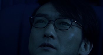 Movie still from “Cold Fish” (2010), directed by Sion Sono – A man wearing glasses looking up into the sky; Extreme Close Up shot, Low angle