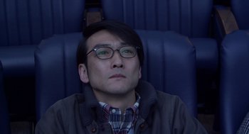 Movie still from “Cold Fish” (2010), directed by Sion Sono – A man sitting in a chair with his eyes wide open; Close Up shot, High angle