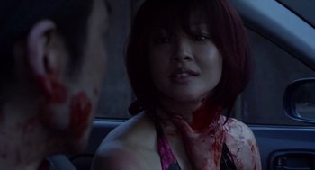 Movie still from “Cold Fish” (2010), directed by Sion Sono – A woman with blood on her face and neck; Close Up shot, Over the shoulder angle