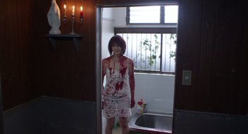 Movie still from “Cold Fish” (2010), directed by Sion Sono – A woman in a white dress with blood all over her body; Medium shot, Over the shoulder angle