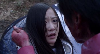 Movie still from “Cold Fish” (2010), directed by Sion Sono – A young woman with long hair and a bruised face; Close Up shot, High angle
