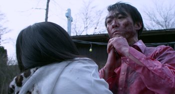 Movie still from “Cold Fish” (2010), directed by Sion Sono – A woman is putting makeup on another woman; Close Up shot, Over the shoulder angle