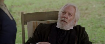 Movie still from “Cold Mountain” (2003), directed by Anthony Minghella – An old man with a beard sitting on a bench; Close Up shot, High angle