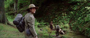 Movie still from “Cold Mountain” (2003), directed by Anthony Minghella – A group of people in the woods near a stream; Medium shot, Over the shoulder angle
