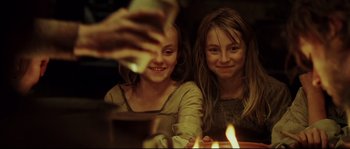 Movie still from “Cold Mountain” (2003), directed by Anthony Minghella – Two young girls sitting in front of a candle; Close Up shot, High angle