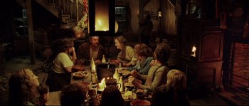 Movie still from “Cold Mountain” (2003), directed by Anthony Minghella – A group of people sitting around a table eating food; Wide shot, High angle