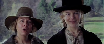 Movie still from “Cold Mountain” (2003), directed by Anthony Minghella – Two women wearing hats and one of them is smiling; Close Up shot, Low angle