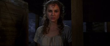 Movie still from “Cold Mountain” (2003), directed by Anthony Minghella – A woman with long curly hair standing next to a wooden post; Close Up shot, Over the shoulder angle