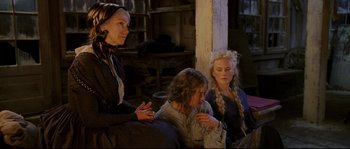 Movie still from “Cold Mountain” (2003), directed by Anthony Minghella – A group of women sitting next to each other on a bench; Medium shot, High angle