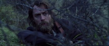 Movie still from “Cold Mountain” (2003), directed by Anthony Minghella – A man with a beard is looking through a fence; Close Up shot, Low angle