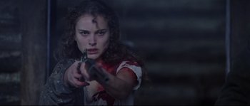 Movie still from “Cold Mountain” (2003), directed by Anthony Minghella – A young woman holding a gun in a dark room; Close Up shot, Over the shoulder angle