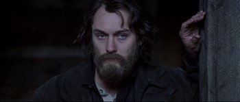 Movie still from “Cold Mountain” (2003), directed by Anthony Minghella – A person with long hair and a beard; Close Up shot, Over the shoulder angle