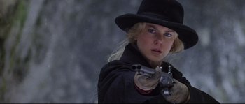A woman wearing a black hat and holding a gun