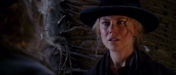 Movie still from “Cold Mountain” (2003), directed by Anthony Minghella – A woman wearing a black hat standing in front of a tree; Close Up shot, Over the shoulder angle