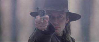 Movie still from “Cold Mountain” (2003), directed by Anthony Minghella – A man holding a gun while wearing a black hat; Close Up shot, Low angle