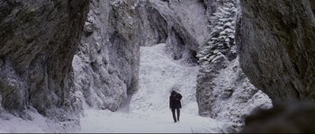 Movie still from “Cold Mountain” (2003), directed by Anthony Minghella – A person walking on a snowy path in the mountains; Extreme Wide shot, High angle