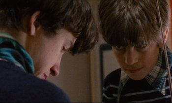 Movie still from “Cold Water” (1994), directed by Olivier Assayas – Two young boys looking at each other in a room; Close Up shot, Over the shoulder angle
