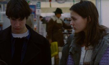 Movie still from “Cold Water” (1994), directed by Olivier Assayas – A man and a woman are walking in a store; Close Up shot, Over the shoulder angle