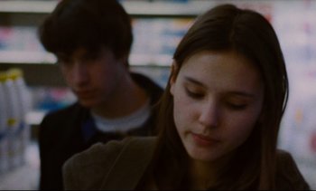 Movie still from “Cold Water” (1994), directed by Olivier Assayas – A young woman and a young man sitting next to each other; Close Up shot, Over the shoulder angle