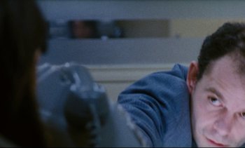 Movie still from “Cold Water” (1994), directed by Olivier Assayas – A person sitting on a couch in a living room; Close Up shot, Low angle