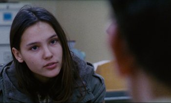 Movie still from “Cold Water” (1994), directed by Olivier Assayas – A young woman sitting in front of another person; Close Up shot, Over the shoulder angle