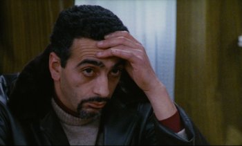 Movie still from “Cold Water” (1994), directed by Olivier Assayas – A person holding his hand to his head; Close Up shot, High angle